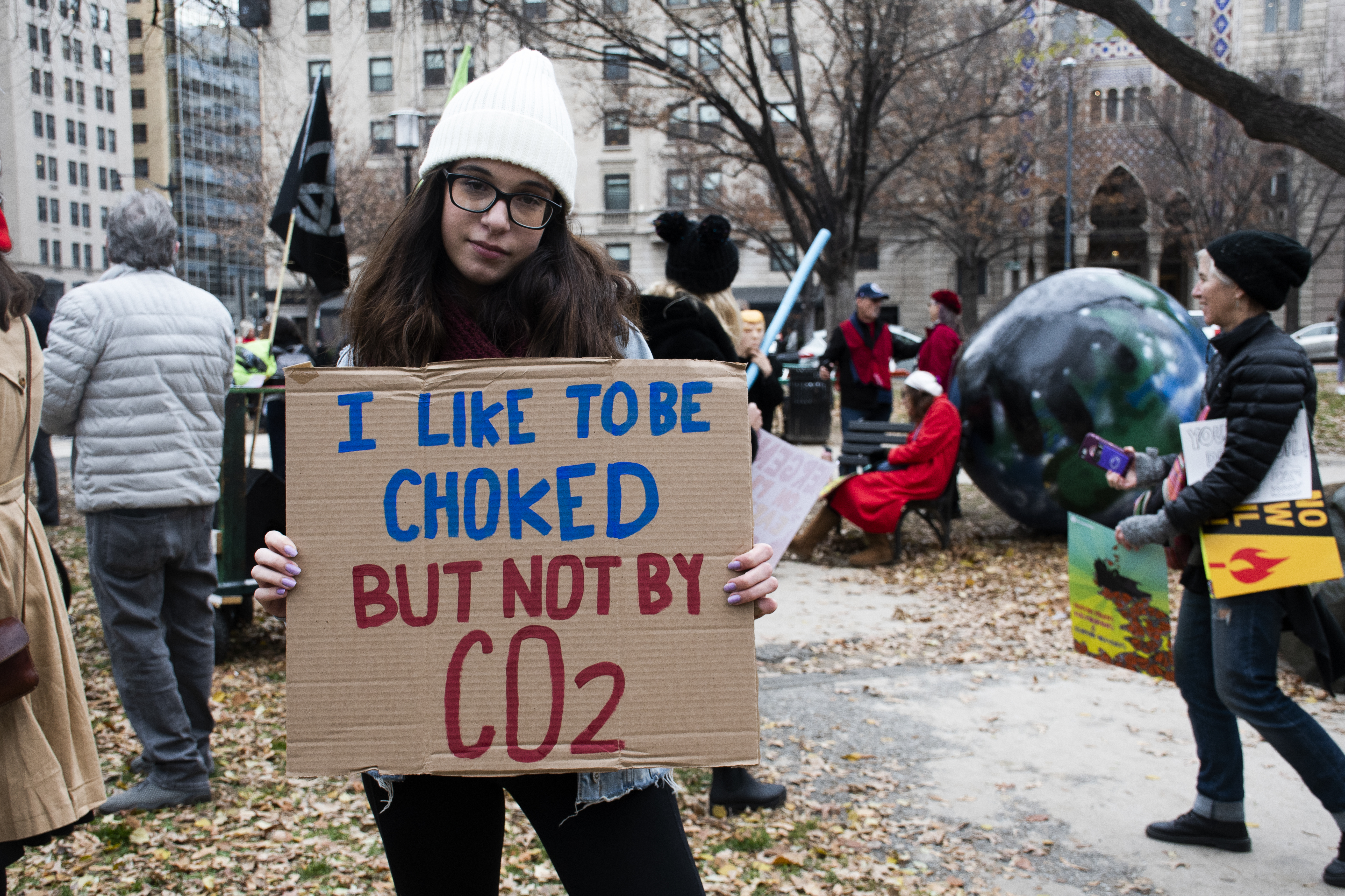 Woman holds up sign that reads: I like to be choked, but not by CO2